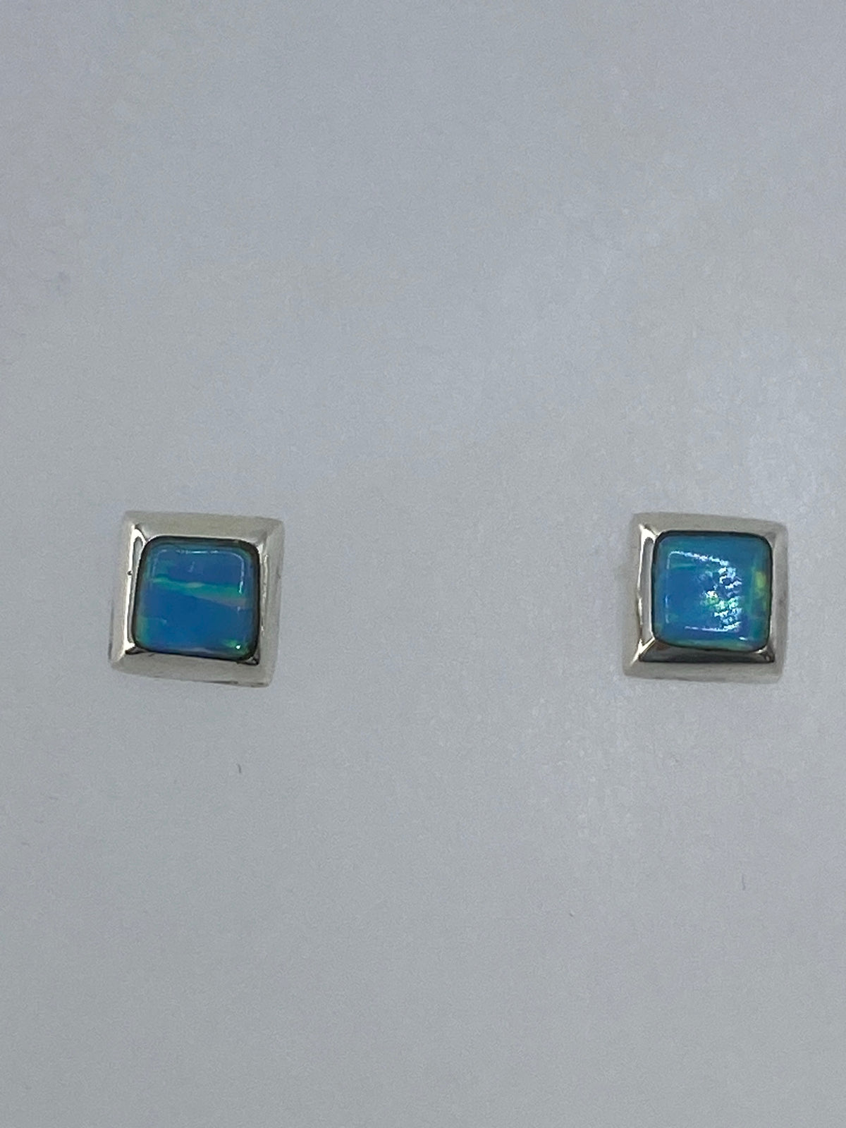 Aretes de plata 925 con ópalo de fuego reflejando luz multicolor