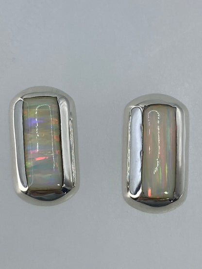 Aretes pequeños de 1.3 cm delante de una regla para escala