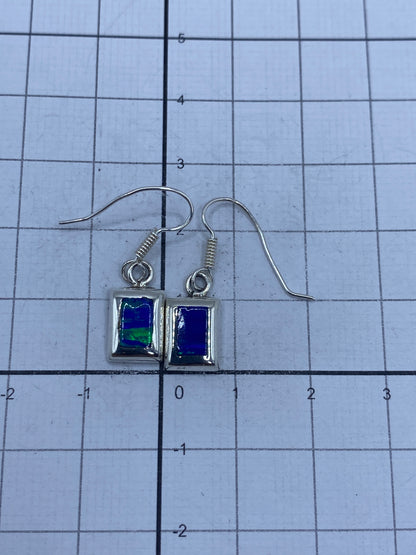 Aretes en la balanza mostrando peso de 1.6 g el par, con sello SKU