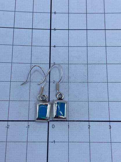 Aretes sobre escala de centímetros mostrando 2.9 cm de largo