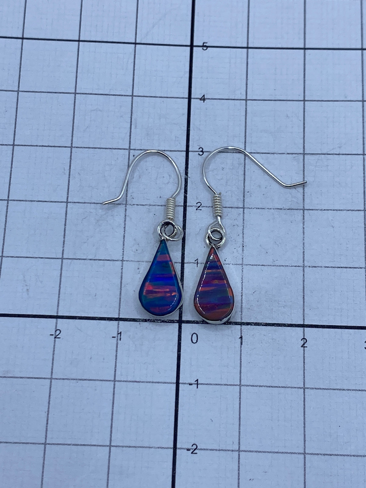 Los dos aretes lado a lado sobre fondo blanco, 3 cm de largo cada uno