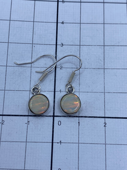 Gancho de plata de los aretes en primer plano con Quinto visible