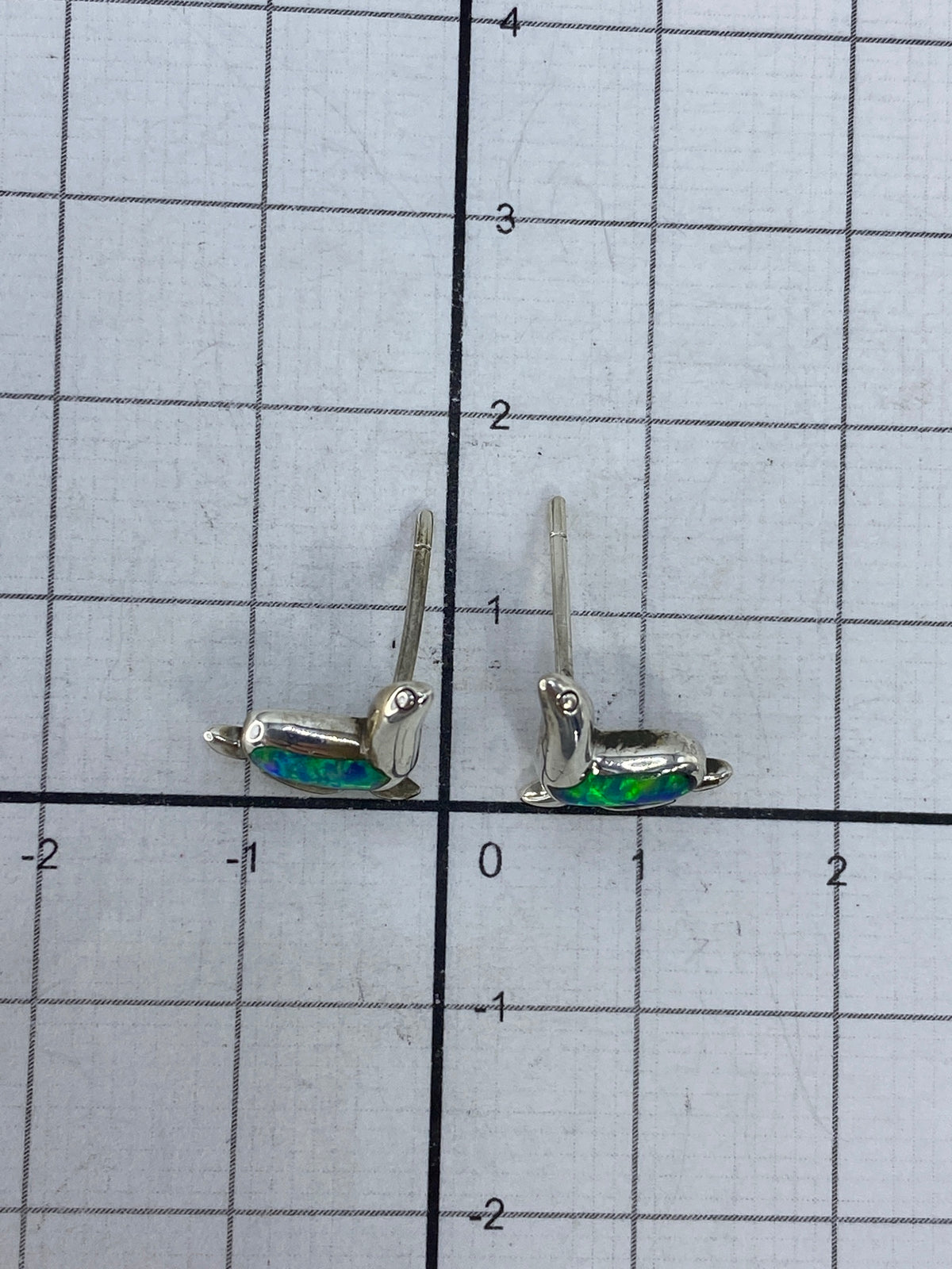 Aretes en la mano mostrando el tamaño real de 1.5 cm