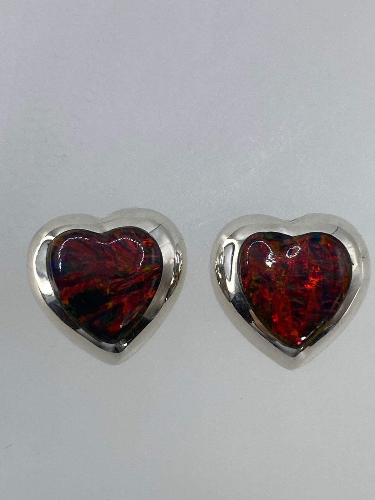 Aretes de ópalo de fuego mostrando los tonos rojo, naranja y amarillo de la piedra