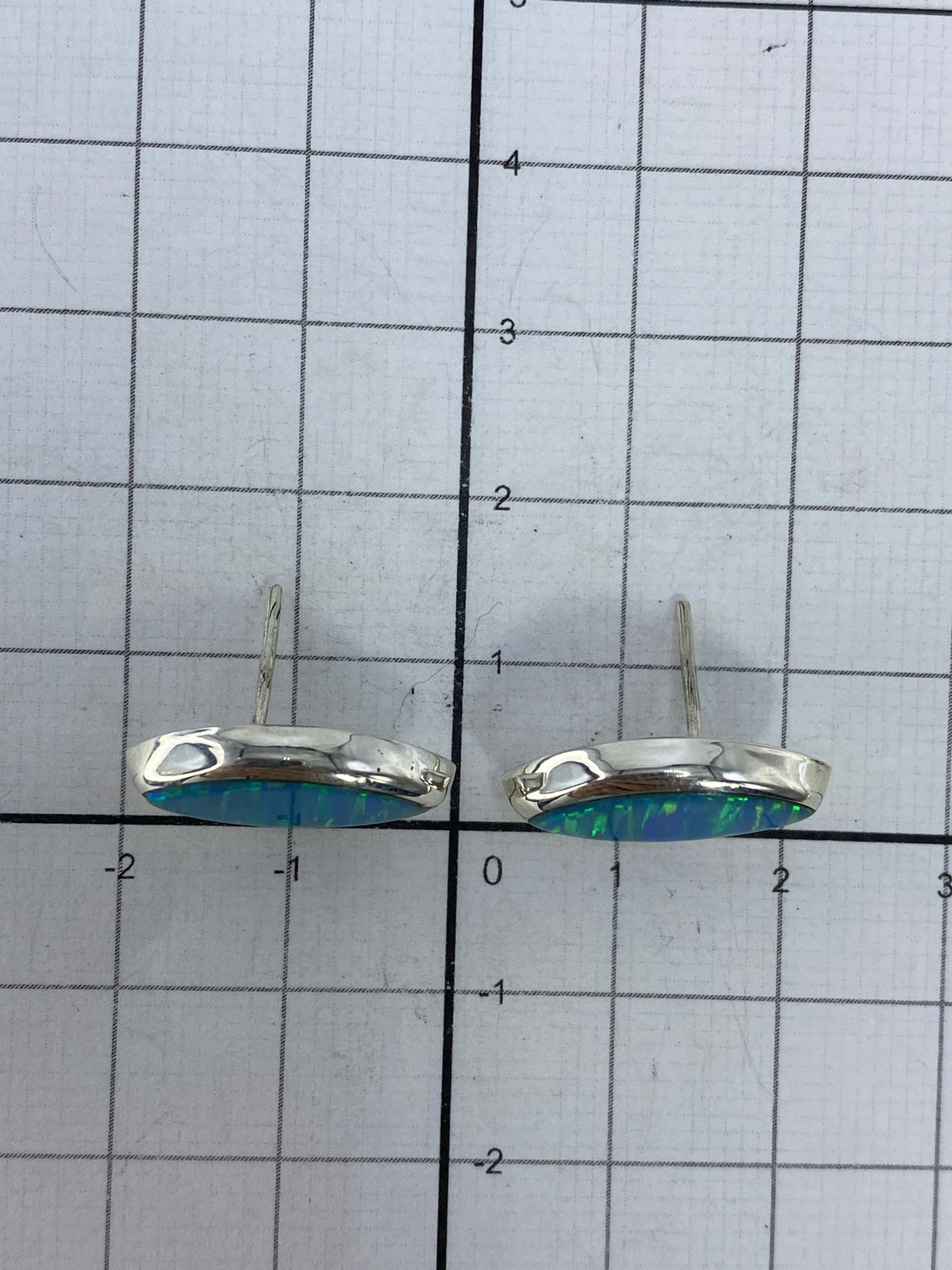 Aretes sobre fondo blanco mostrando el gancho y la medida real de 1.5 cm