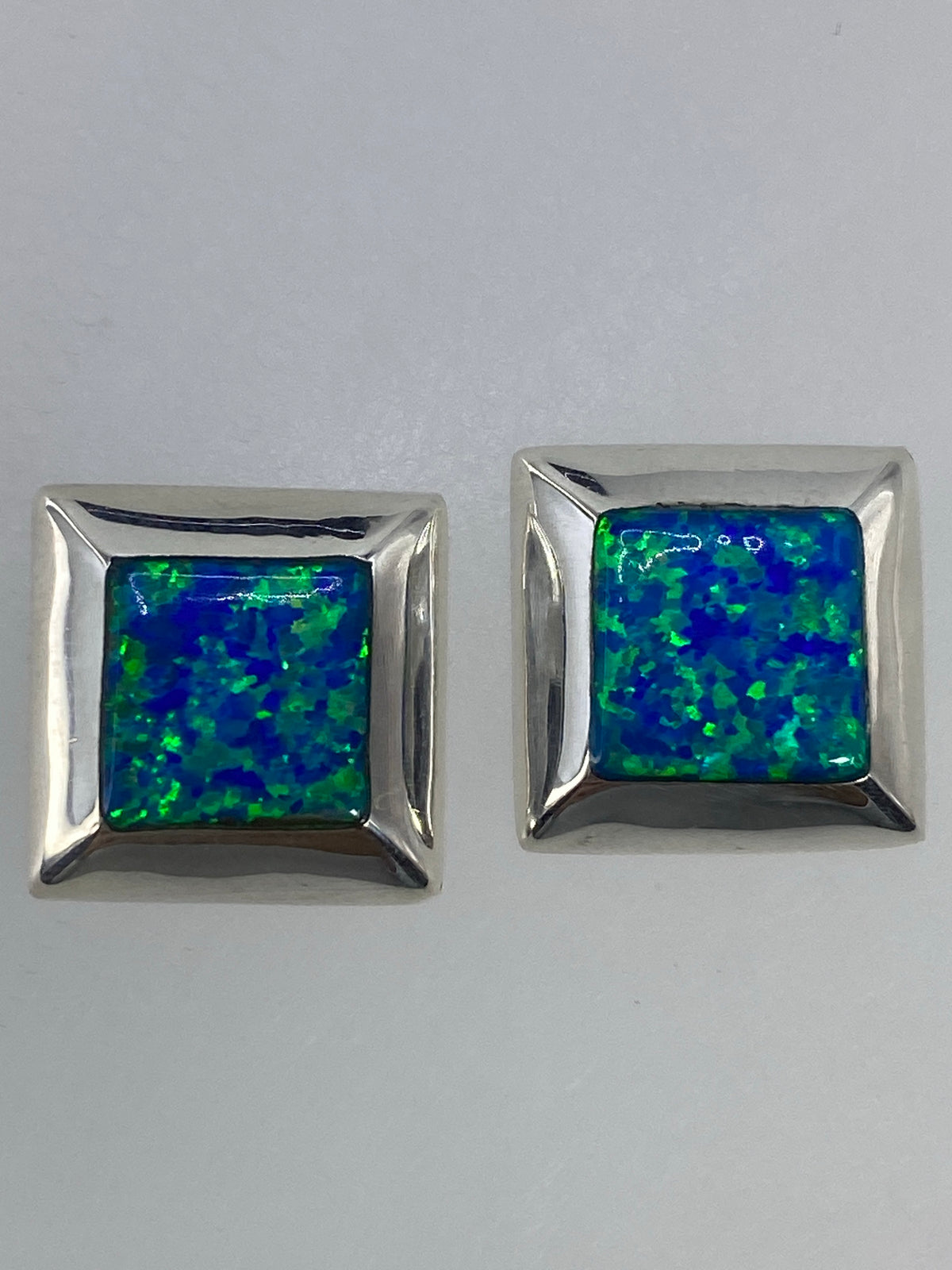 Aretes de plata 925 con ópalo de fuego engastado, vista frontal mostrando el tamaño compacto de 1.3 cm