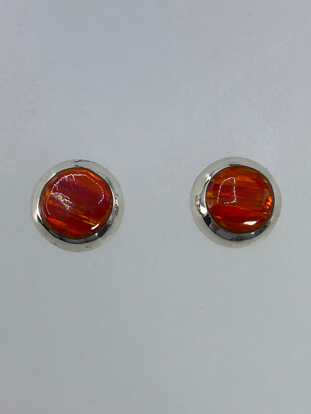 Par de aretes de plata 925 con ópalo de fuego naranja engastado a mano, sobre fondo blanco