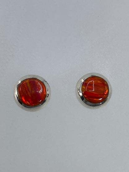 Detalle del ópalo de fuego naranja con juegos de luz dorado en el arete izquierdo