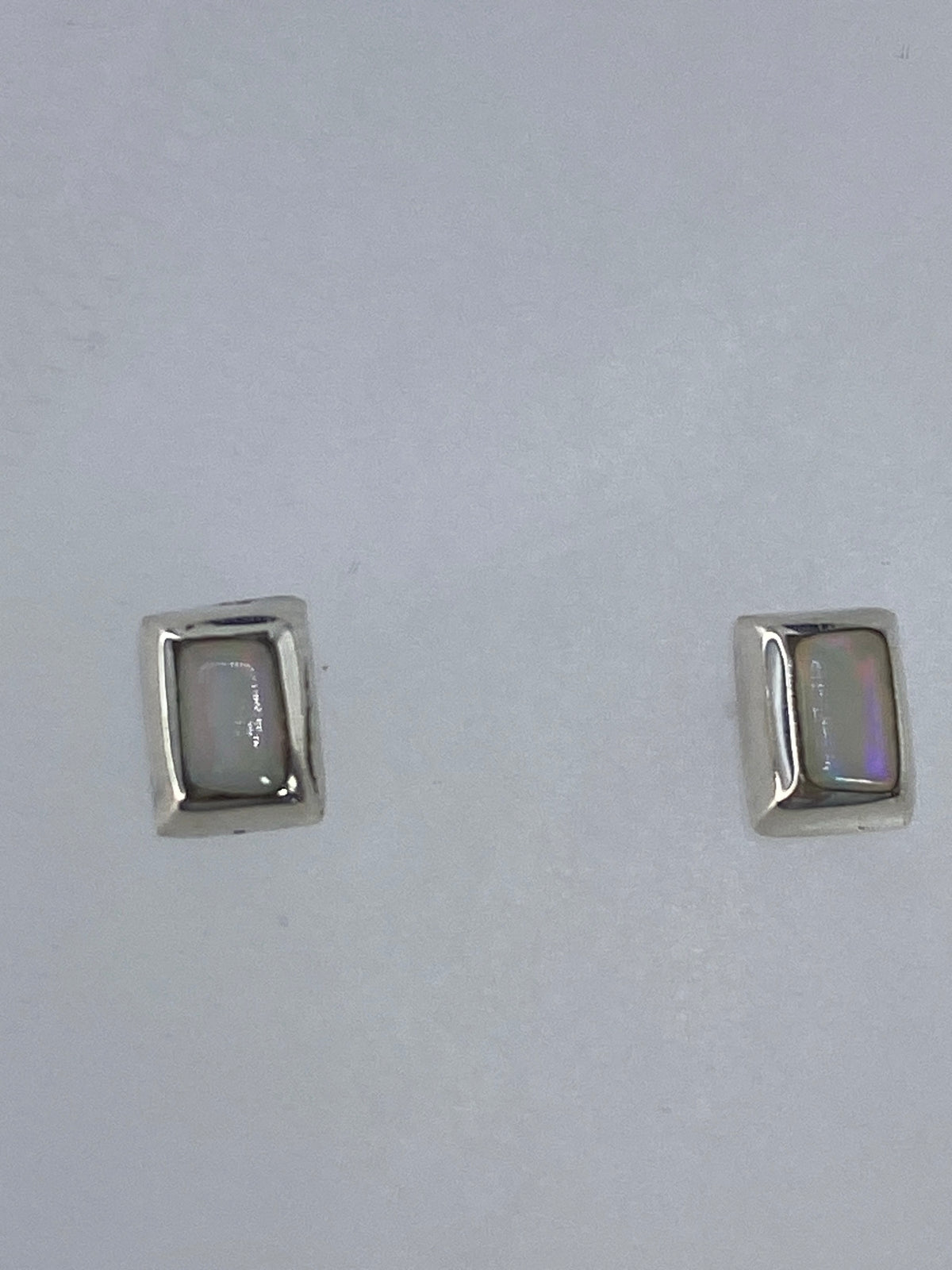 Detalle del opalo de fuego en aretes de plata 925, mostrando sus colores iridiscentes