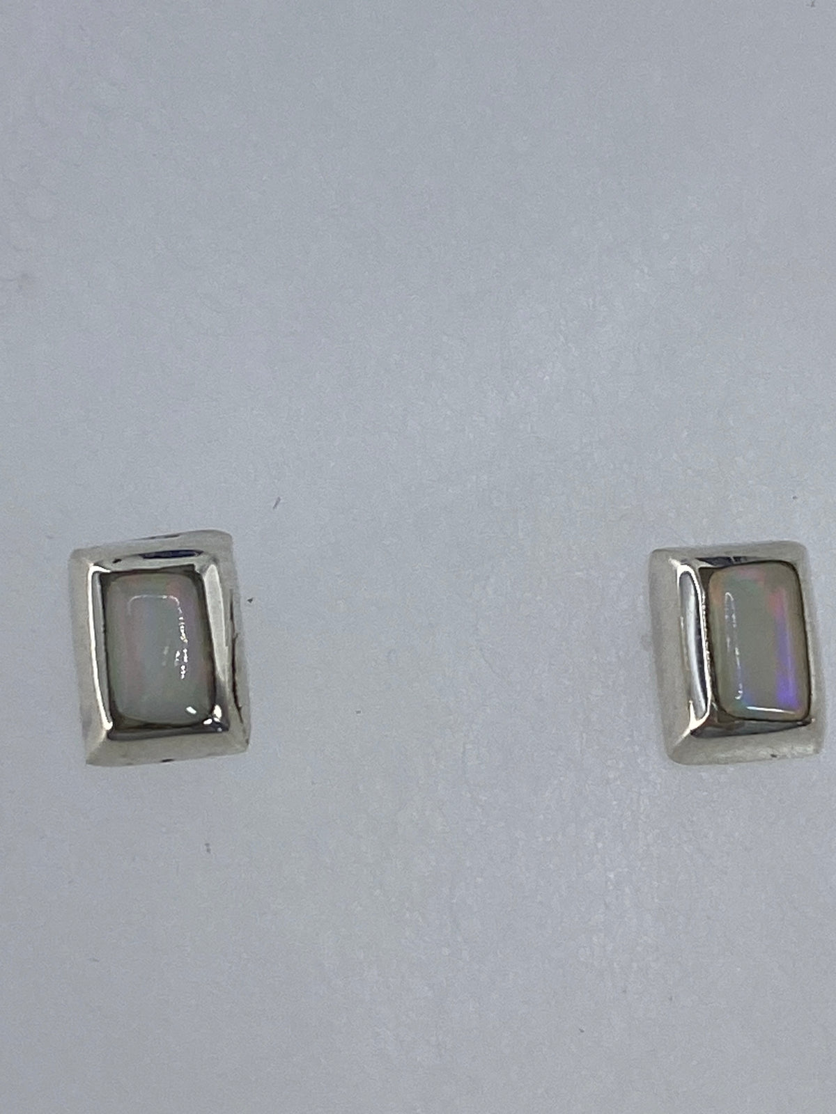 Aretes de plata con opalo de fuego sobre escala de medidas, largo 1.2 cm