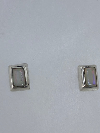 Aretes de plata con opalo de fuego sobre escala de medidas, largo 1.2 cm
