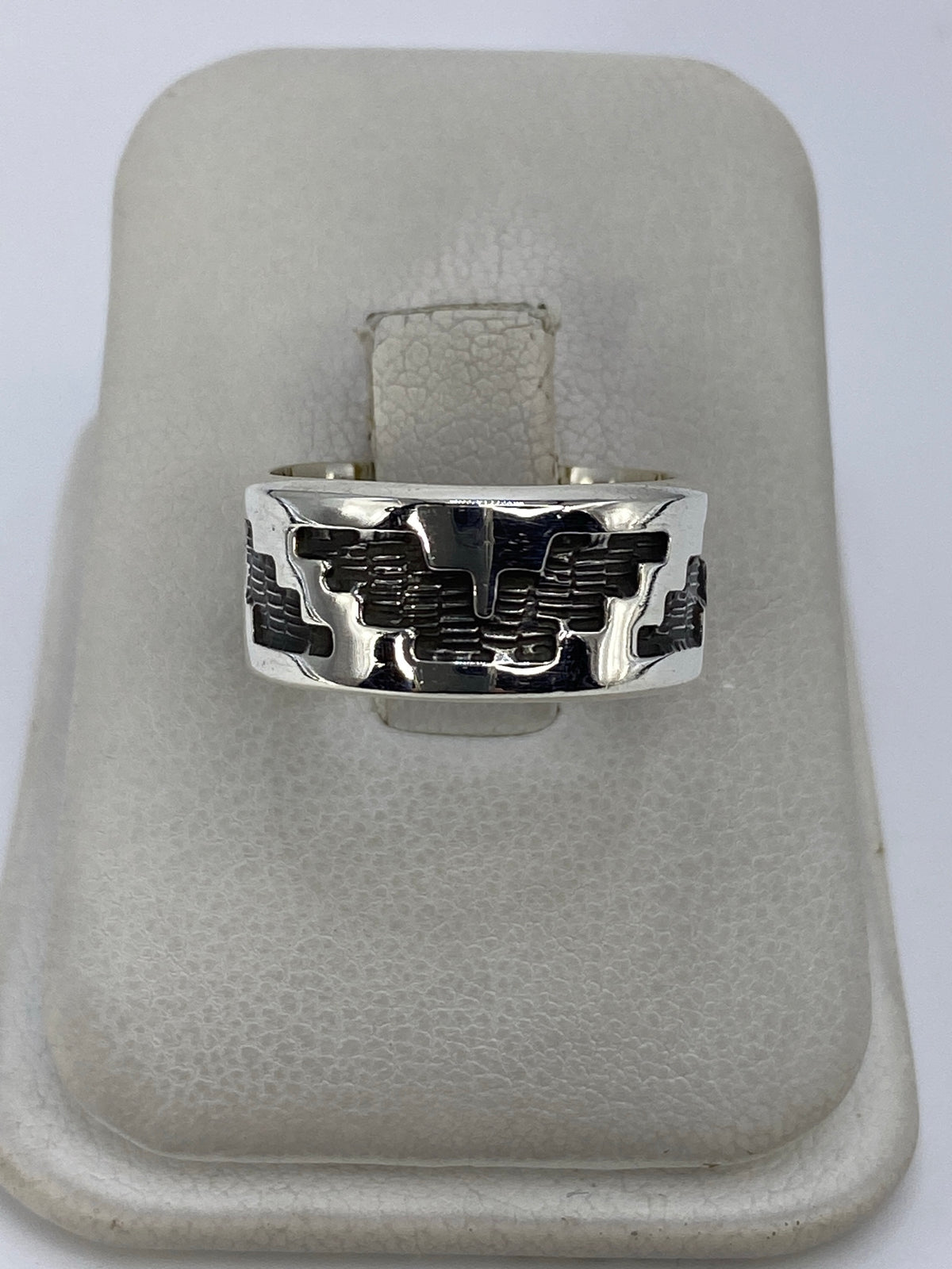 Anillo de plata repujado con motivo prehispánico en relieve visto de frente