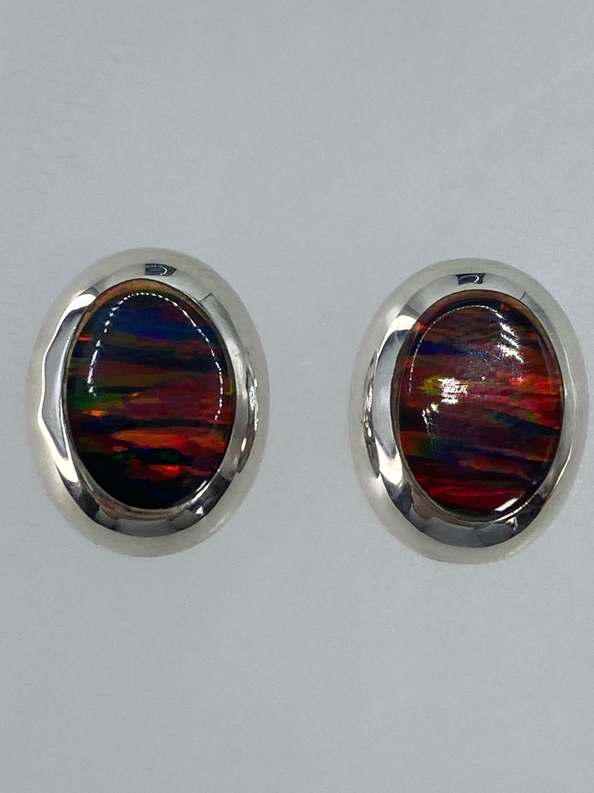 Detalle de los aretes mostrando el fuego rojo, naranja y azul del ópalo