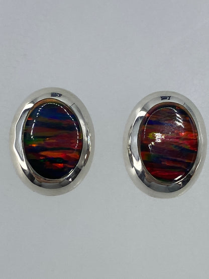 Detalle de los aretes mostrando el fuego rojo, naranja y azul del ópalo