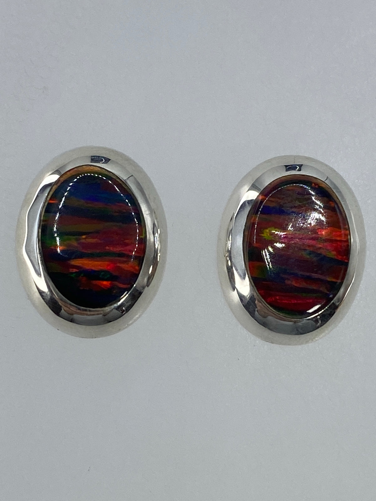 Aretes sobre escala de medidas mostrando el tamaño compacto de 1.5 cm