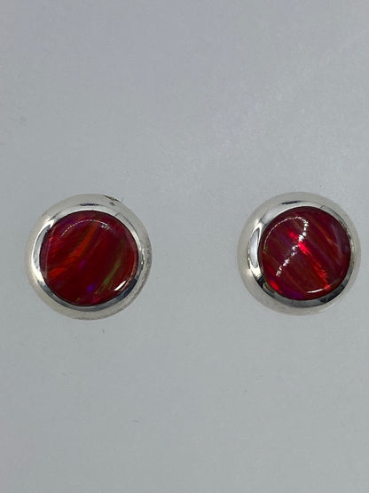 Par de aretes de plata con ópalo de fuego rojo brillante en posición frontal