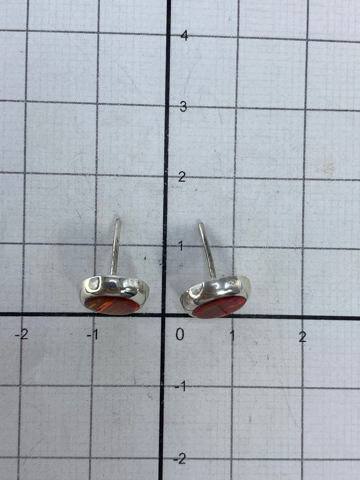 Aretes sobre escala de precisión, pesando 1.28 gramos total