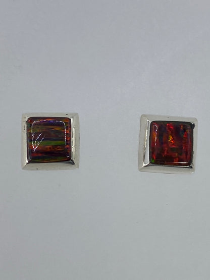 Par de aretes de plata con ópalo de fuego multicolor brillando en tonos rojos y naranjas