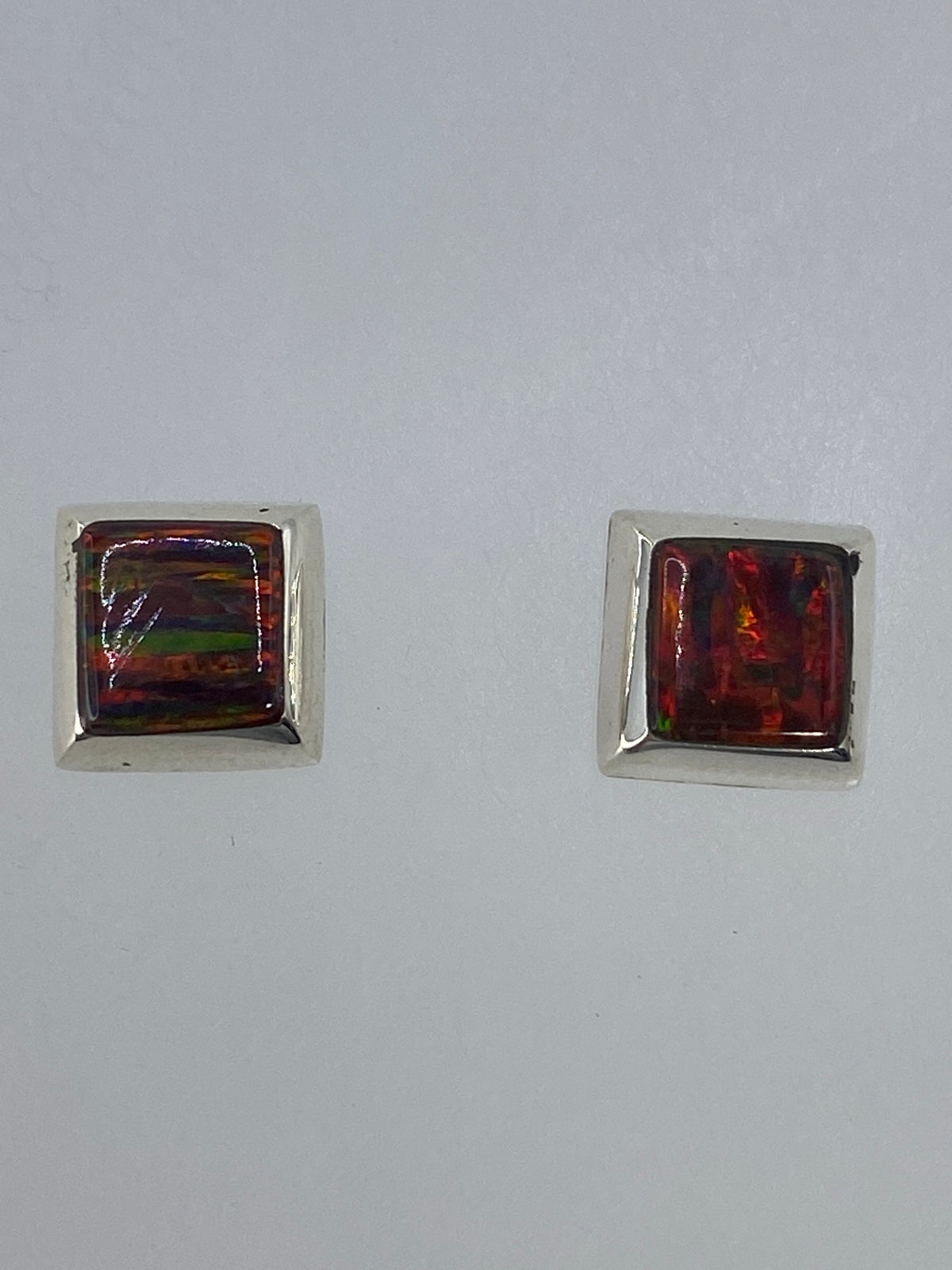Aretes sobre escala milimétrica mostrando su tamaño delicado de 1.5 cm