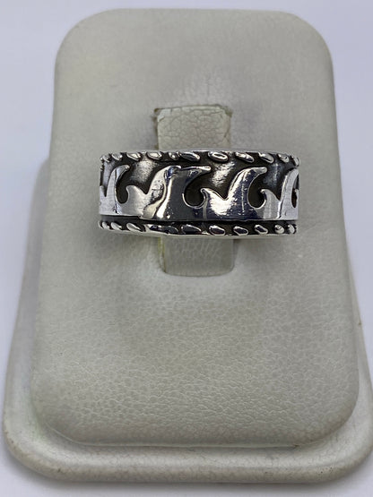 Anillo de plata repujado con líneas geométricas en la mano de una persona