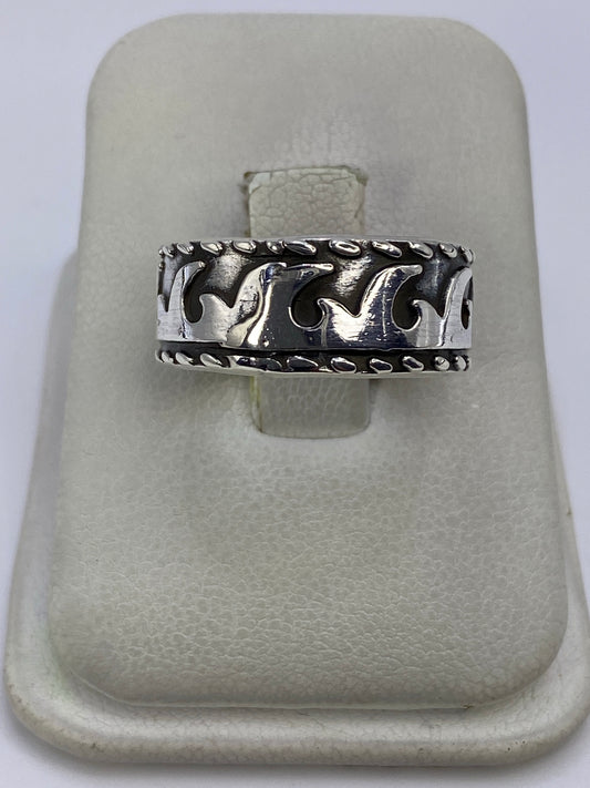 Anillo de plata repujado con líneas geométricas en la mano de una persona