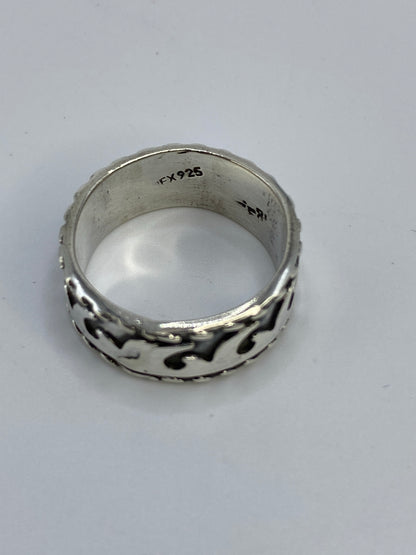 Anillo sobre fondo azul exhibiendo el acabado satinado y la geometría fluida