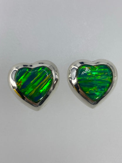 Par de aretes de plata con ópalo de fuego multicolor, forma de corazón, sobre fondo blanco