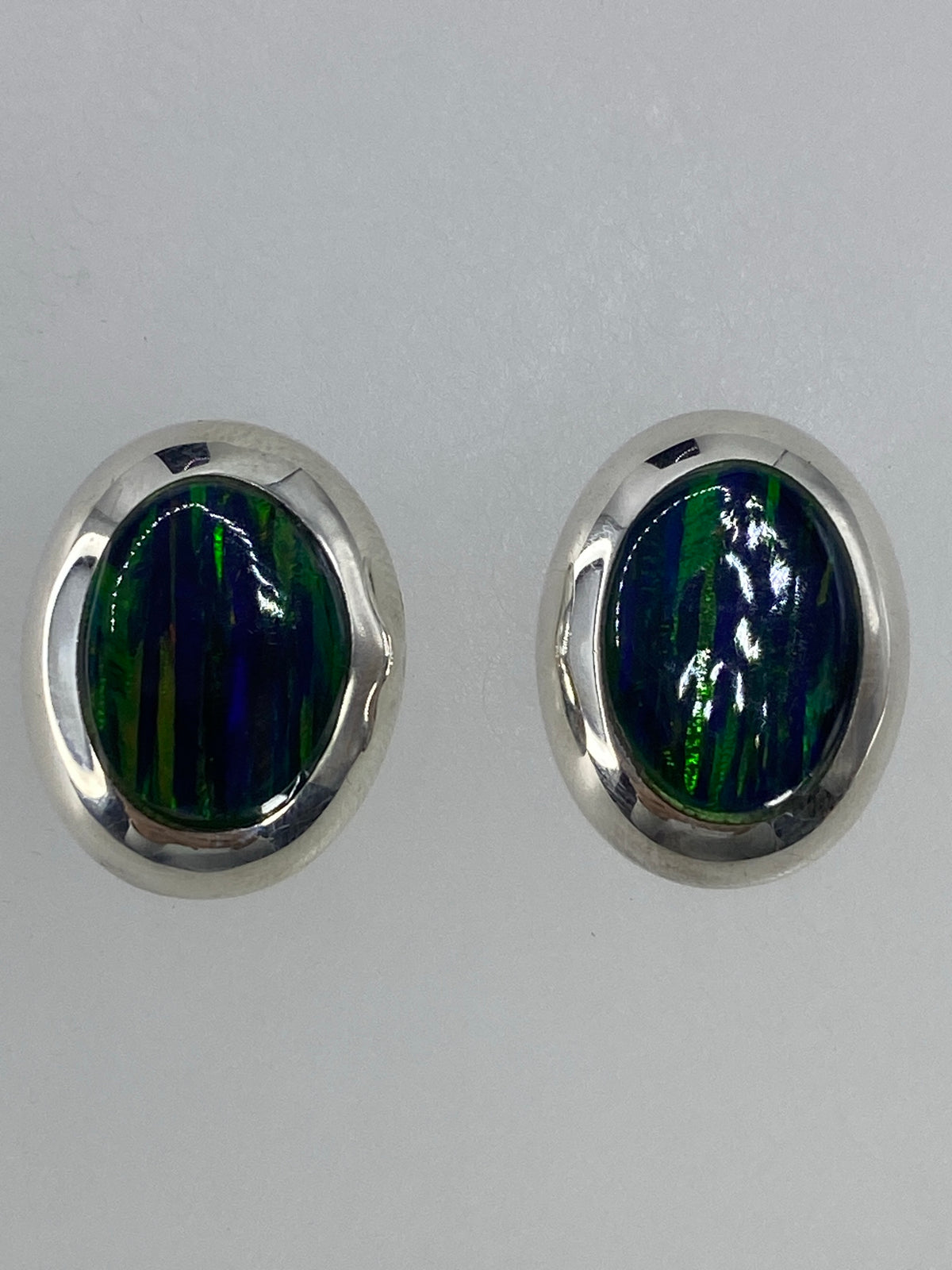 Detalle lateral de los aretes con engaste de ópalo de fuego en plata 925