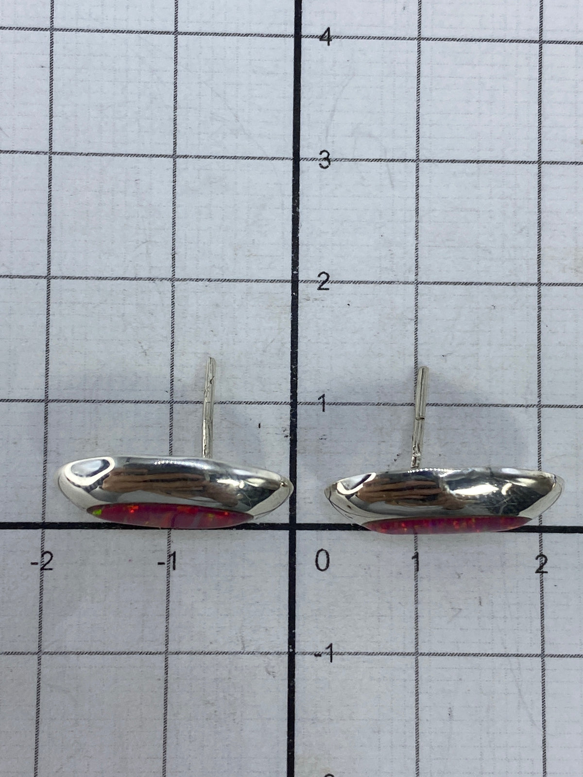 Reverso de los aretes mostrando el Quinto 925 y el poste de plata