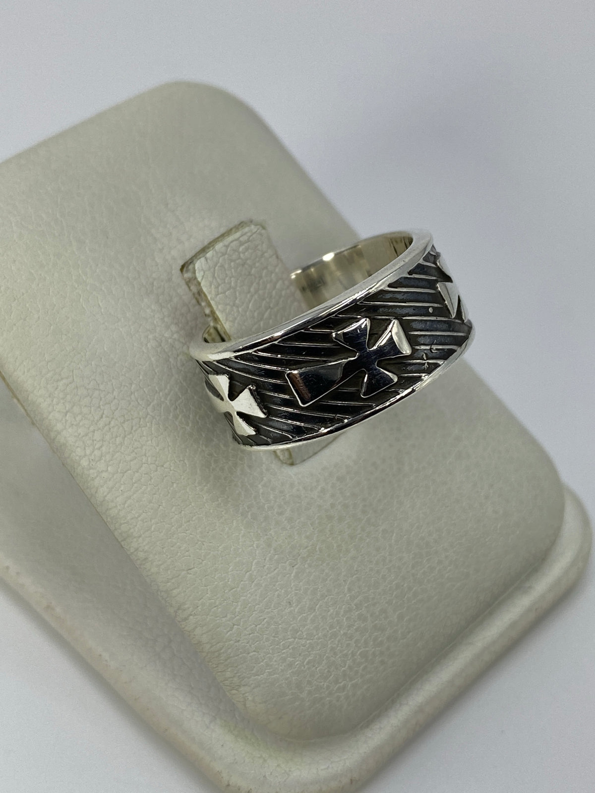 Detalle del anillo mostrando el repujado de cruces y el contraste de pulido