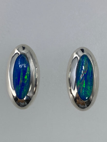 Par de aretes de plata con ópalo de fuego verde limón, brillando bajo la luz