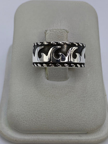 Anillo de plata repujado con patrón étnico visto de frente en la mano