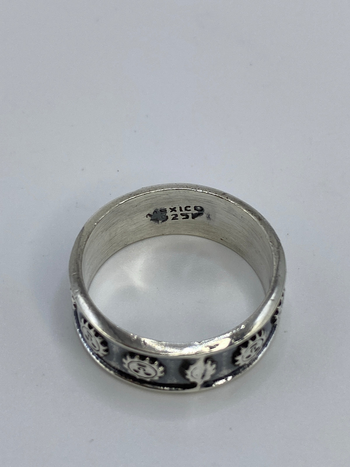 Anillo en talla 10 sobre mano mostrando el acabado patinado y los motivos del sol