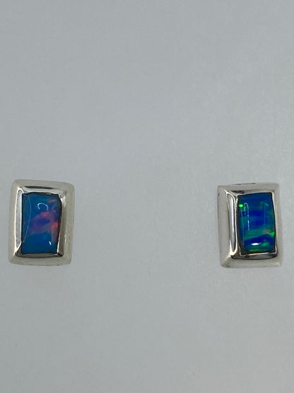 Detalle de un arete mostrando el engaste de ópalo de fuego en plata pulida