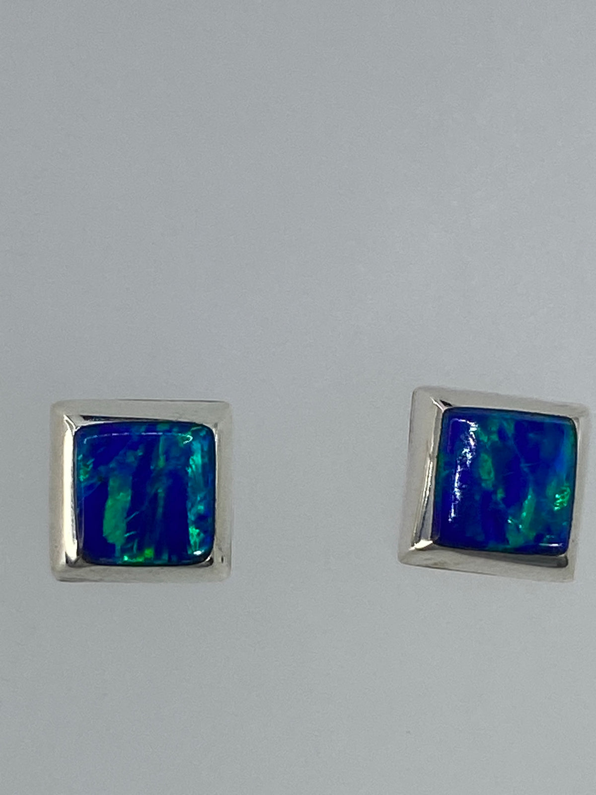 Par de aretes de plata con ópalo de fuego verde limón sobre fondo blanco