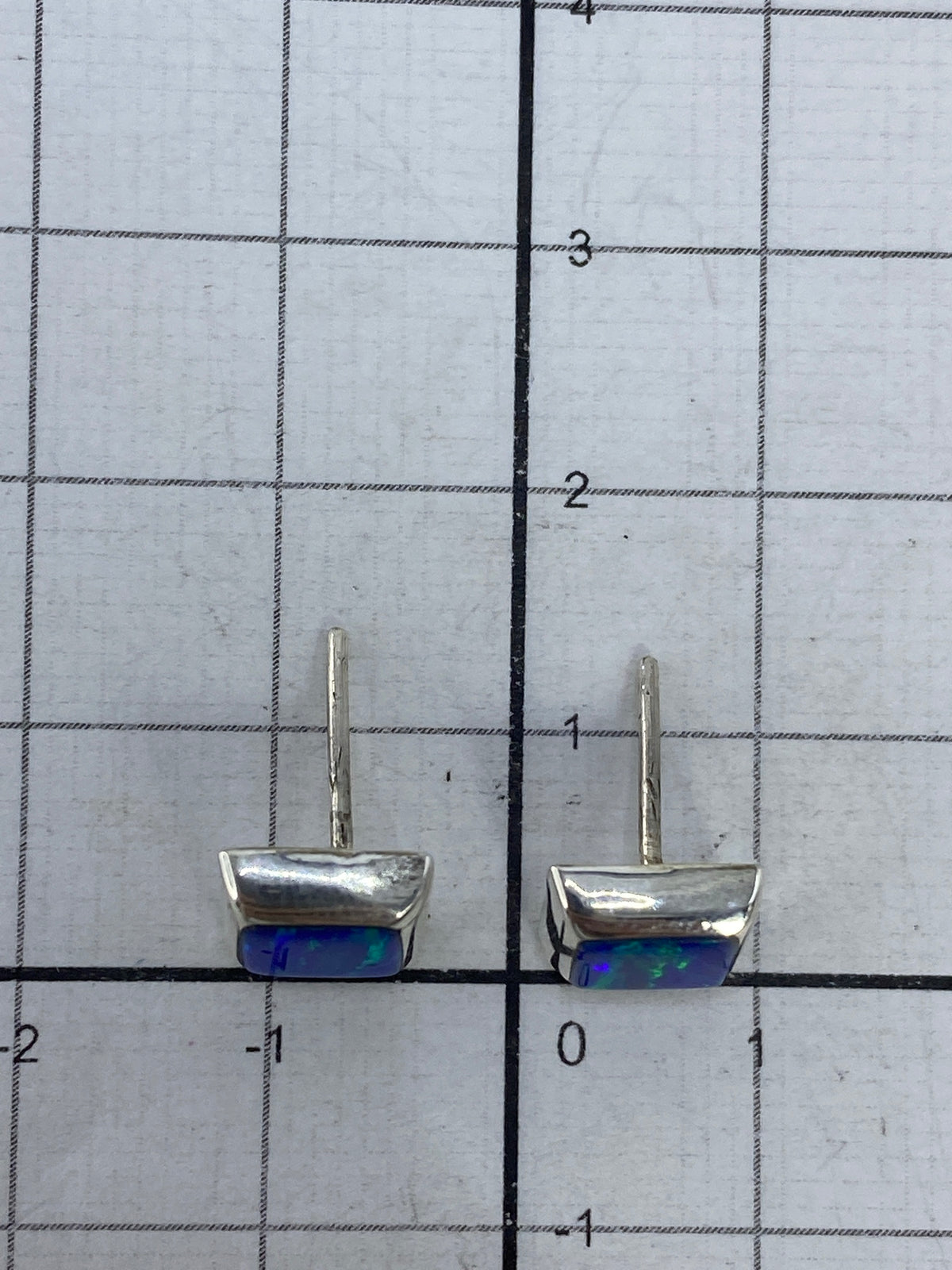 Aretes junto a regla métrica mostrando 1.2 cm de largo