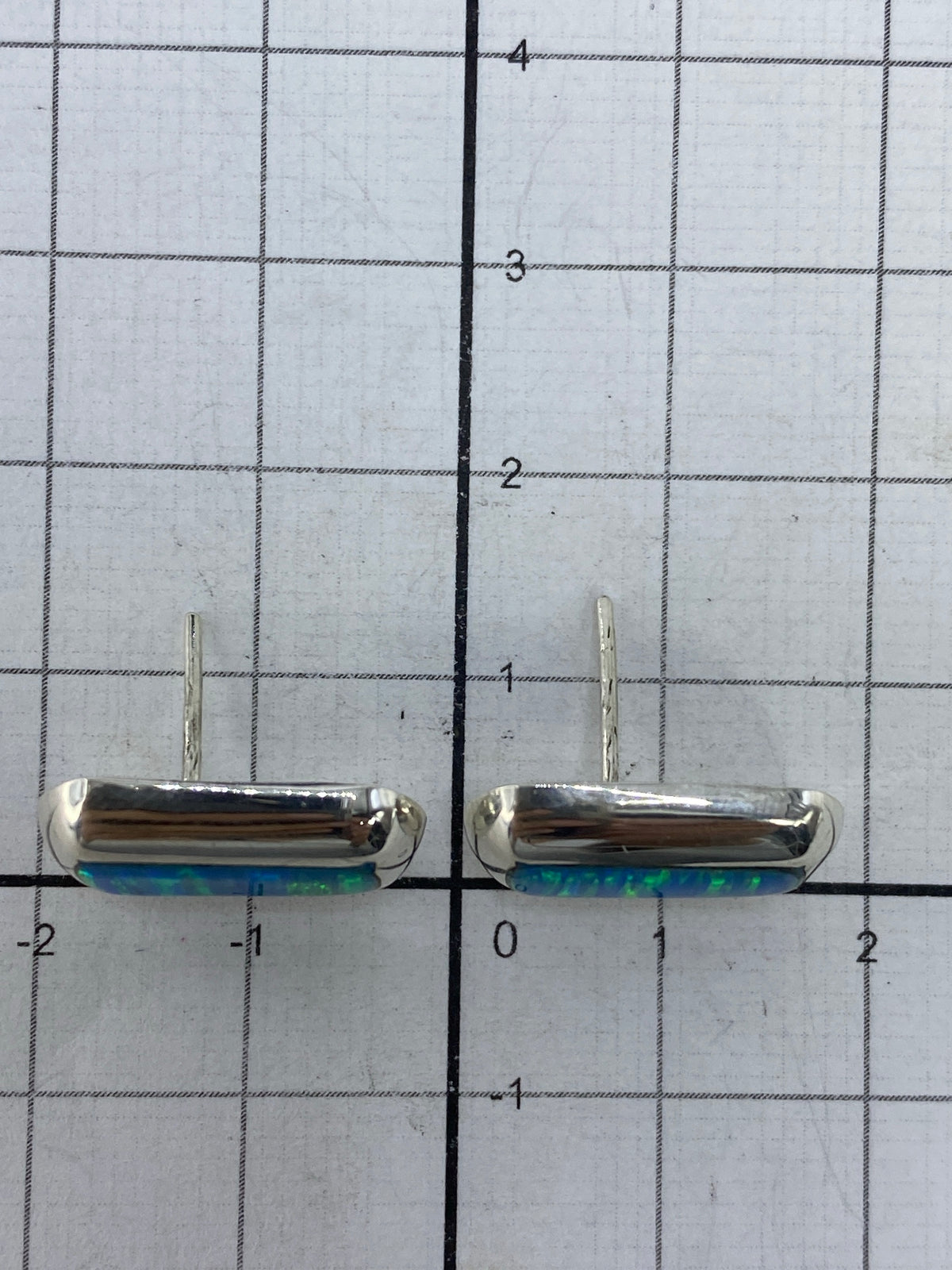 Aretes sobre fondo blanco con el Quinto 925 visible en la plata
