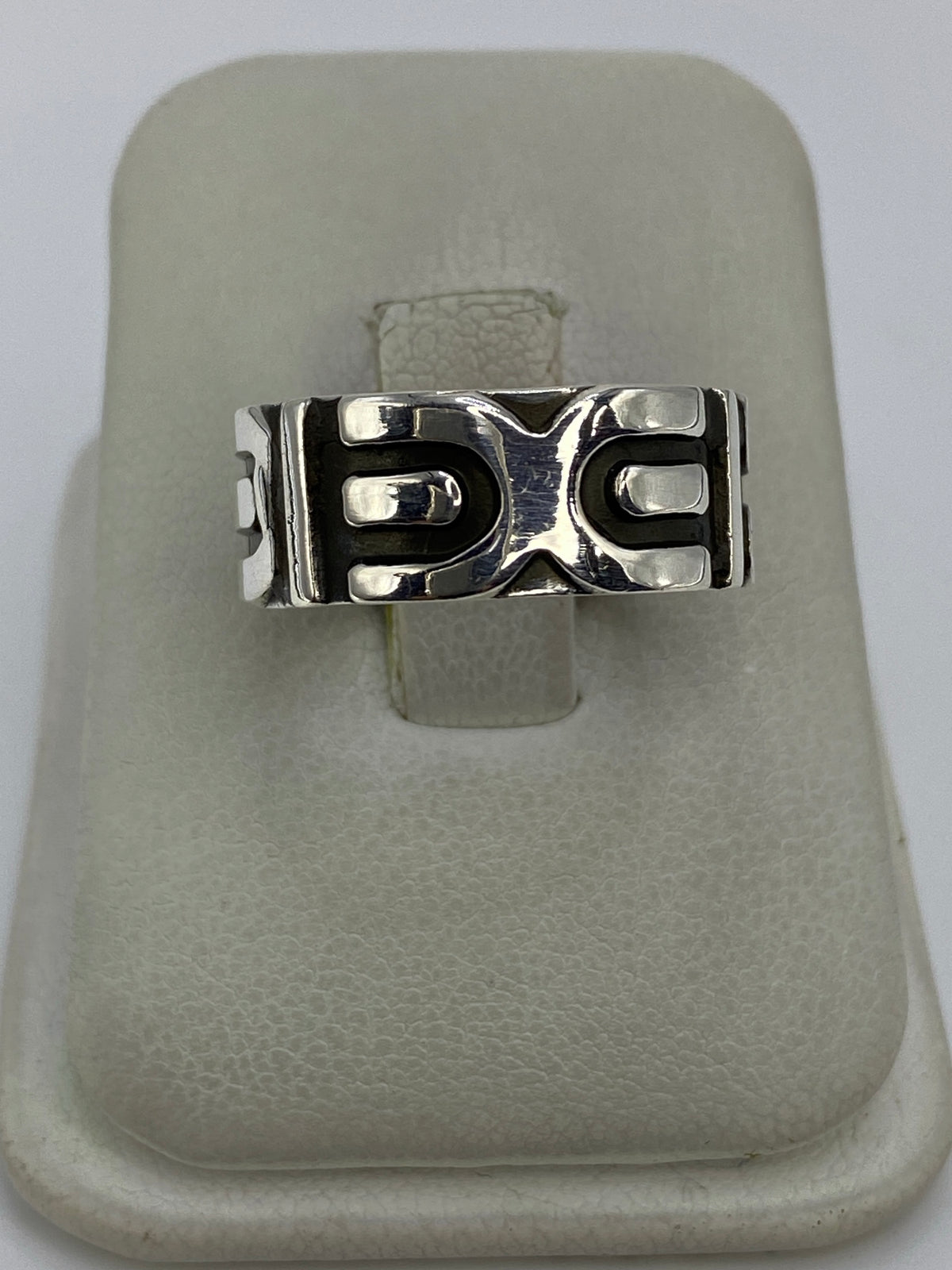 Anillo de plata repujado con diseño geométrico minimalista en la mano