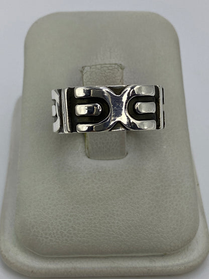 Anillo de plata repujado con diseño geométrico minimalista en la mano