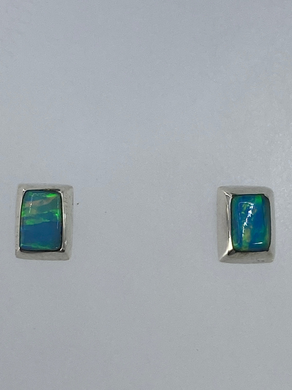 Par de aretes de plata 925 con ópalo de fuego verde limón engastado, sobre fondo gris