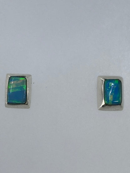 Detalle del engaste a mano del ópalo de fuego en plata, vista frontal de un arete