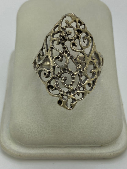 Anillo de plata calado con diseño abierto en la mano de una mujer
