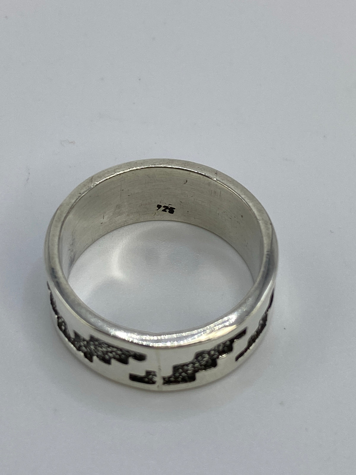 Anillo repujado puesto en la mano mostrando el efecto visual del diseño