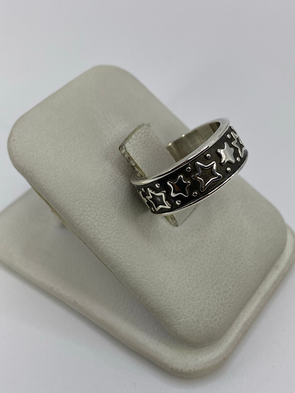 Anillo de plata repujado con estrellas de Taxco en la mano, mostrando el relieve artesanal