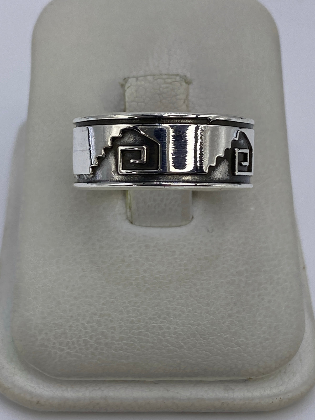 Anillo de plata repujado con motivos prehispánicos sobre fondo blanco