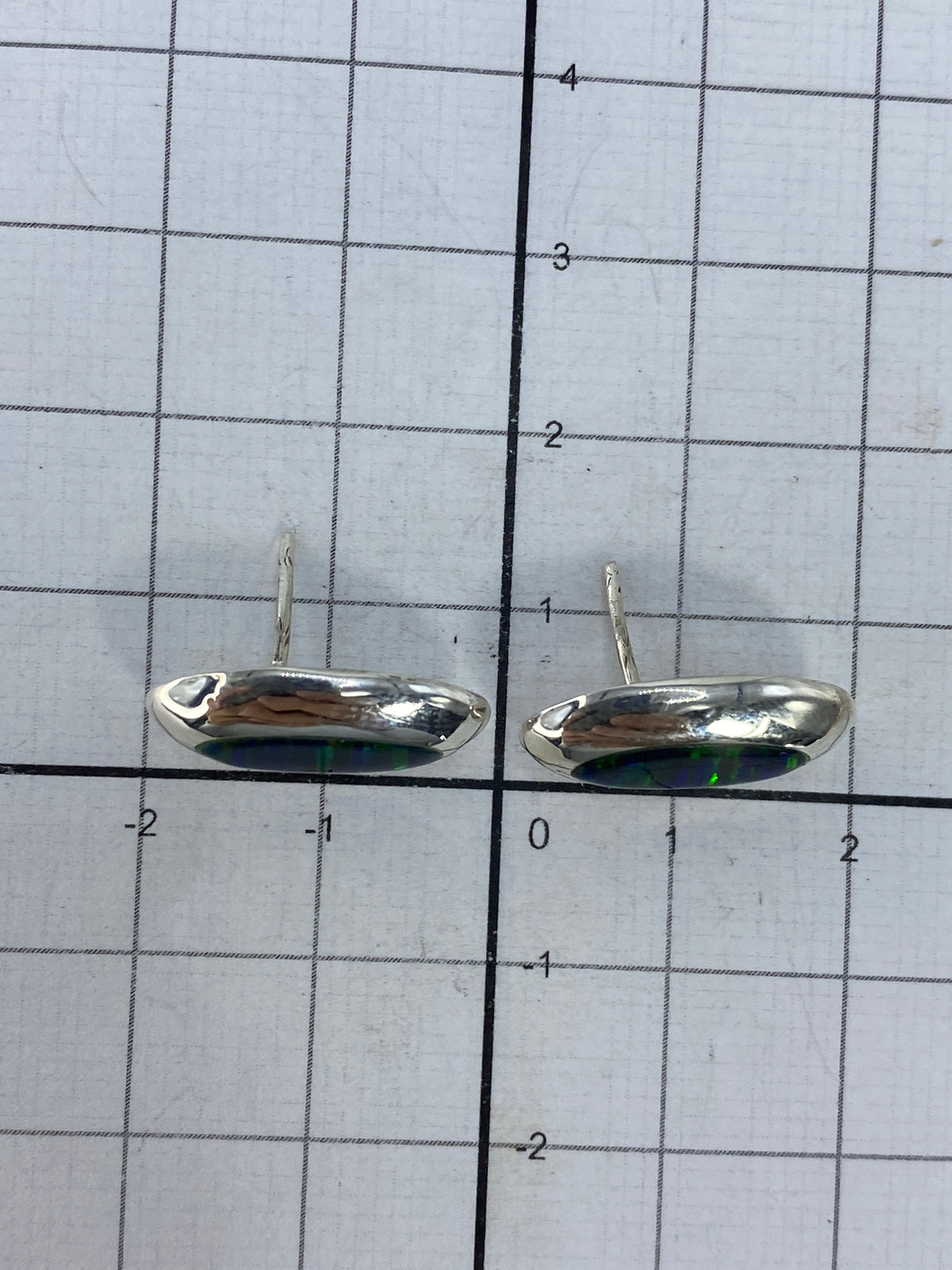 Reverso de los aretes mostrando el Quinto 925 y post de plata