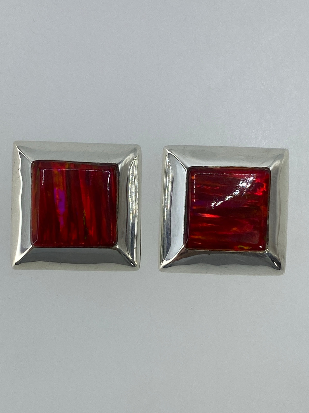 Par de aretes cuadrados de plata con ópalo de fuego rojo, sobre fondo blanco