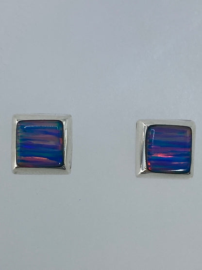 Vista frontal de los aretes mostrando el color multicolor del ópalo de fuego