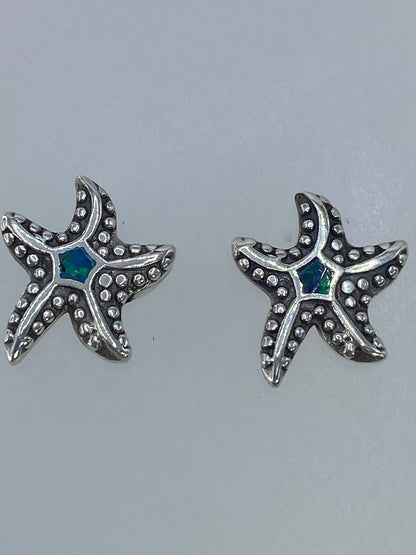 Aretes en miniatura con postes de plata, junto a escala de medidas en centímetros