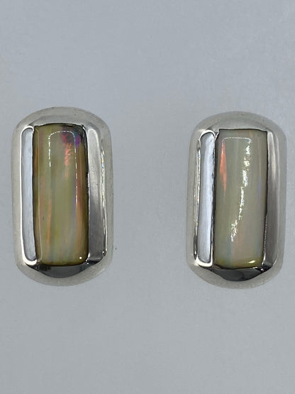 Aretes sobre fondo blanco evidenciando los reflejos multicolor del ópalo